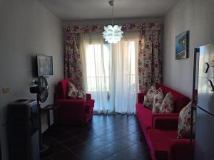 a living room with two red couches and a window at شاليهات بورتو مطروح فيو بحر Porto Matrouh Sea View Families Only in Marsa Matruh