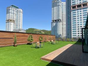 eine Terrasse mit Tischen und Stühlen in einer Stadt mit hohen Gebäuden in der Unterkunft Hotel Icc in Daejeon