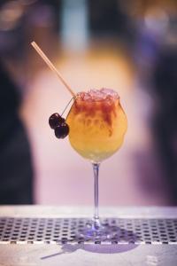 a drink in a glass sitting on a table at Hôtel Bastide in Onet le Château