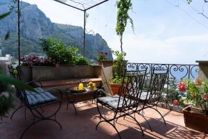 eine Terrasse mit Stühlen und einem Tisch mit Aussicht in der Unterkunft Villa Castello Apartments in Capri