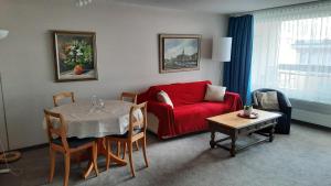 a living room with a red couch and a table at Holiday accommodation - swimming pool available in Davos