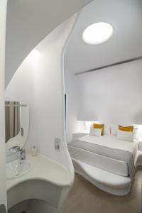 Baño blanco con cama y lavabo en Hotel Boutique Suite Generis, Premiado El hotel más acogedor de España, en Córdoba