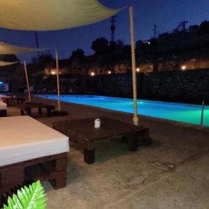 a patio with a table and a pool at night at Hotel Don Juan in Puente de Génave