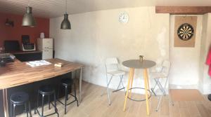 a kitchen with a table and stools in a room at La Prévôté in Marchenoir +11 photos