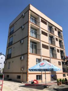 a building with a blue umbrella and a building at Chaki Hotel in Ureki