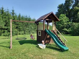 a playground with a slide and a swing at Rūnēnu tējas namiņš in Vidzeme