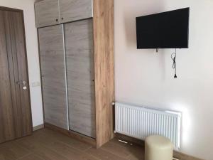 a room with a tv on a wall with a cabinet at Chaki Hotel in Ureki