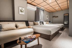 una camera d'albergo con due letti e un divano di ZZINN,penghu a Magong