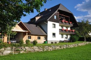 uma grande casa branca com um telhado preto em Pension Kreischberg Mayer em Sankt Lorenzen ob Murau