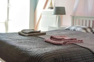 a bed with three towels on top of it at Sweet Nest Apartment in Giżycko