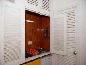 una cocina con armarios blancos y un bol de fruta en Estudio with sea view Cala Martina, en Cala Llena