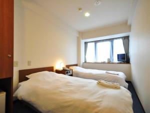 a bedroom with a bed and a window at Hotel Koshien in Nishinomiya