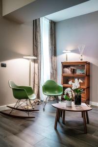 a living room with two green chairs and a table at In Centro Luxury Rooms in Como