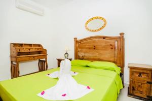 Un dormitorio con una cama verde con un vestido. en Gorgeous 22 People Villa With Pool Playacar Phase 2, en Playa del Carmen