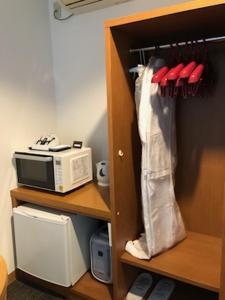 ein Schrank mit einer Mikrowelle und einem Toaster in der Unterkunft Hotel Plaisir Tachikawa in Tachikawa