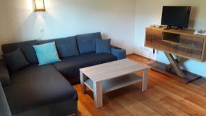 a living room with a blue couch and a table at Ferienwohnung Appesbacher in St. Wolfgang