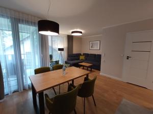 a living room with a wooden table and chairs at Apartamenty Woda i Las in Turawa