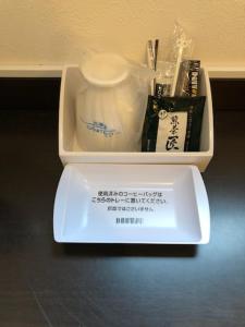 una caja con cepillo de dientes y otros artículos. en Hotel Plaisir Tachikawa en Tachikawa