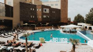 una piscina con gente sentada en sillas en un hotel en Hotel Terra Balneo&Spa en Galaţi