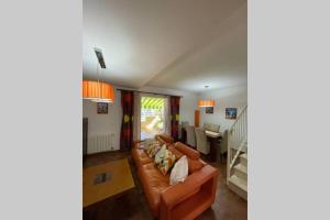 a living room with a couch and a table at Casa adosada con porche, piscina y pista de pádel, junto al campo de golf in El Portil +20 photos