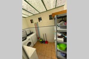 a laundry room with a washer and a washing machine at Casa adosada con porche, piscina y pista de pádel, junto al campo de golf in El Portil