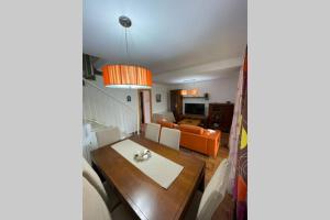 a living room with a table and a couch at Casa adosada con porche, piscina y pista de pádel, junto al campo de golf in El Portil