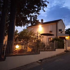 una casa blanca con una valla y una sombrilla en B&B Il Giardino, en Tavullia