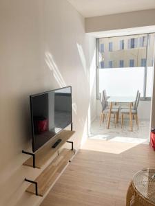 salon z telewizorem z płaskim ekranem na ścianie w obiekcie Halévy Résidence w Nicei