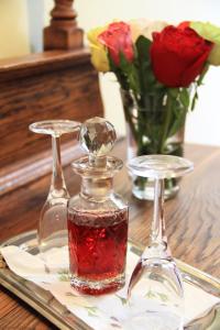 a glass perfume bottle on a table with roses at Evergreen Lodge in Stellenbosch