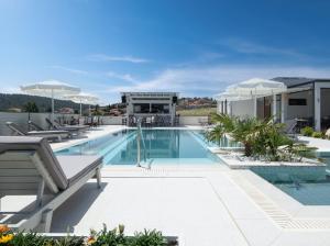 une piscine avec chaises et parasols sur un immeuble dans l'établissement Terra Olivia Luxury Villas and Suites, à Paliouri