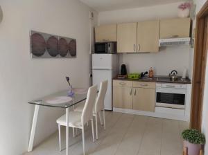 una pequeña cocina con mesa y electrodomésticos blancos en Studio apartment with private terrace, Jacuzzi & views, en Mosta