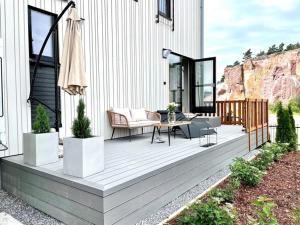 a wooden deck with a table and chairs on a house at Lomavuokra Hanko, Laituri B4, Itäsatama in Hanko