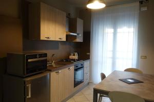 a small kitchen with a table and a microwave at Raimondo's Apartment in Alba