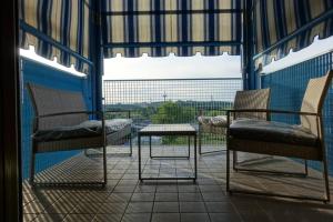 two chairs and a table on a balcony with a view at Raimondo's Apartment in Alba