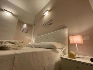 a bedroom with a bed with two words on the wall at Donna Grazia Relais in Gallipoli