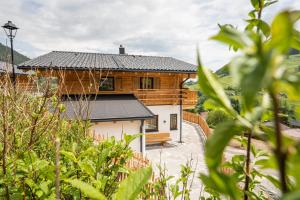 a wooden house with a black roof at Almdorf Auszeit Fageralm in Forstau