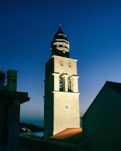 Una torre alta con un reloj encima. en Marko Apartment en Korčula