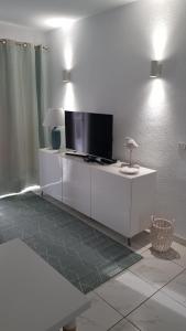 a living room with a flat screen tv on a white cabinet at Karin's Beach Loft, Playa del Cura in Playa del Cura +16 photos