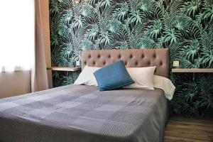 a bedroom with a bed with a blue pillow on it at Hôtel Saint-Florent, à 2 pas du Théatre Antique d'Orange in Orange