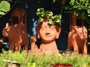 une statue avec une plante au-dessus de sa tête dans l'établissement The Coral Tree Boutique Homestay, à Agra