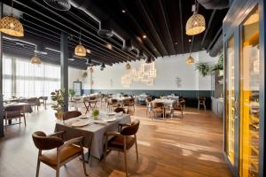 a dining room with tables and chairs and lights at HOTEL IBERUM in Illescas