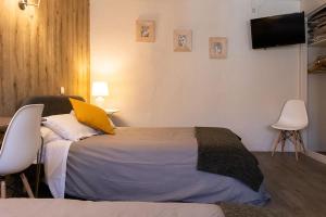 1 dormitorio con 1 cama y TV en la pared en Hôtel Saint Florent, en Orange