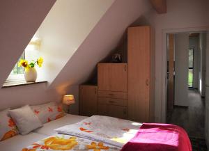 een slaapkamer met een bed met een roze deken bij Ferienwohnung Storchennest Spreewald in Burg Kauper