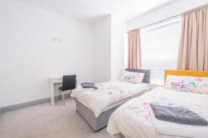 a bedroom with two beds and a desk in it at Portrush Marine Apartments flat1 in Portrush