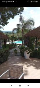 uma vista para um resort com uma piscina e uma cadeira em Le Zagare em Lascari