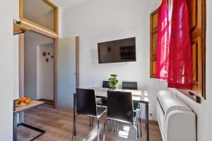 comedor con mesa, sillas y TV en Uffizi Gallery Cozy Flat en Florence