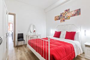 Un dormitorio blanco con una cama roja y una silla en Uffizi Gallery Cozy Flat en Florence