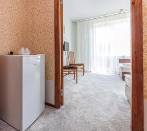a living room with a refrigerator and a table at Poilsio namai "Vyturys" in Palanga