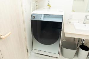 a microwave oven in a kitchen next to a sink at Villa Roppongi in Tokyo +21 photos