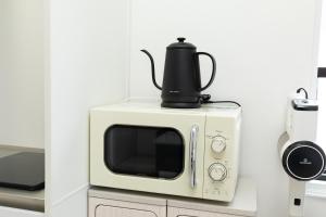 a microwave with a tea kettle on top of it at Villa Roppongi in Tokyo